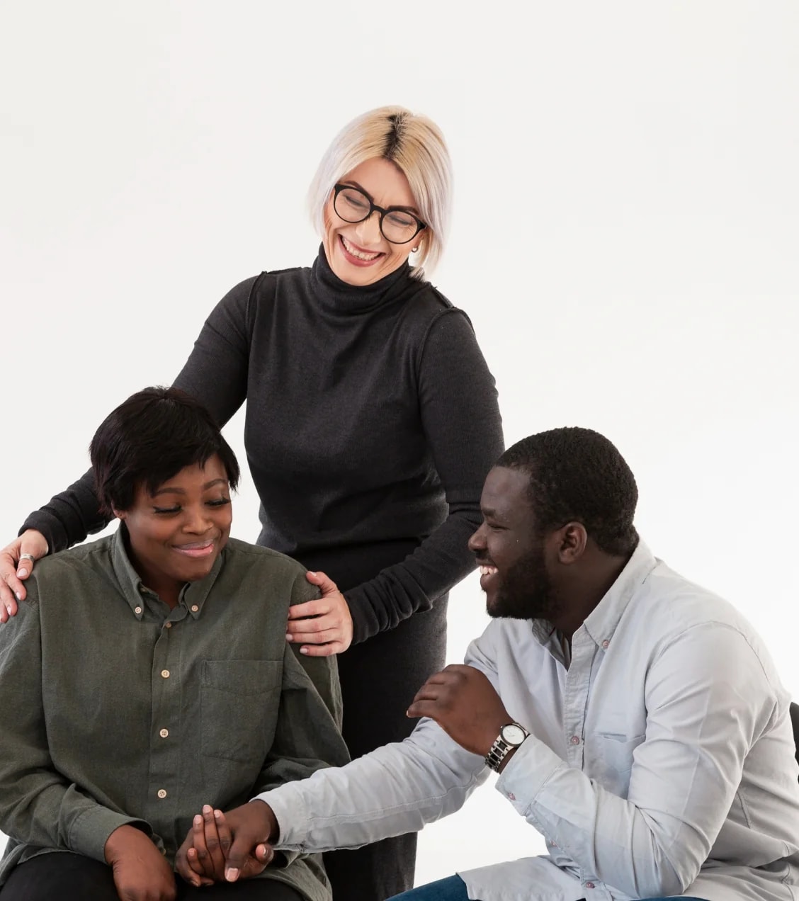 A family sitting together, holding hands in support.