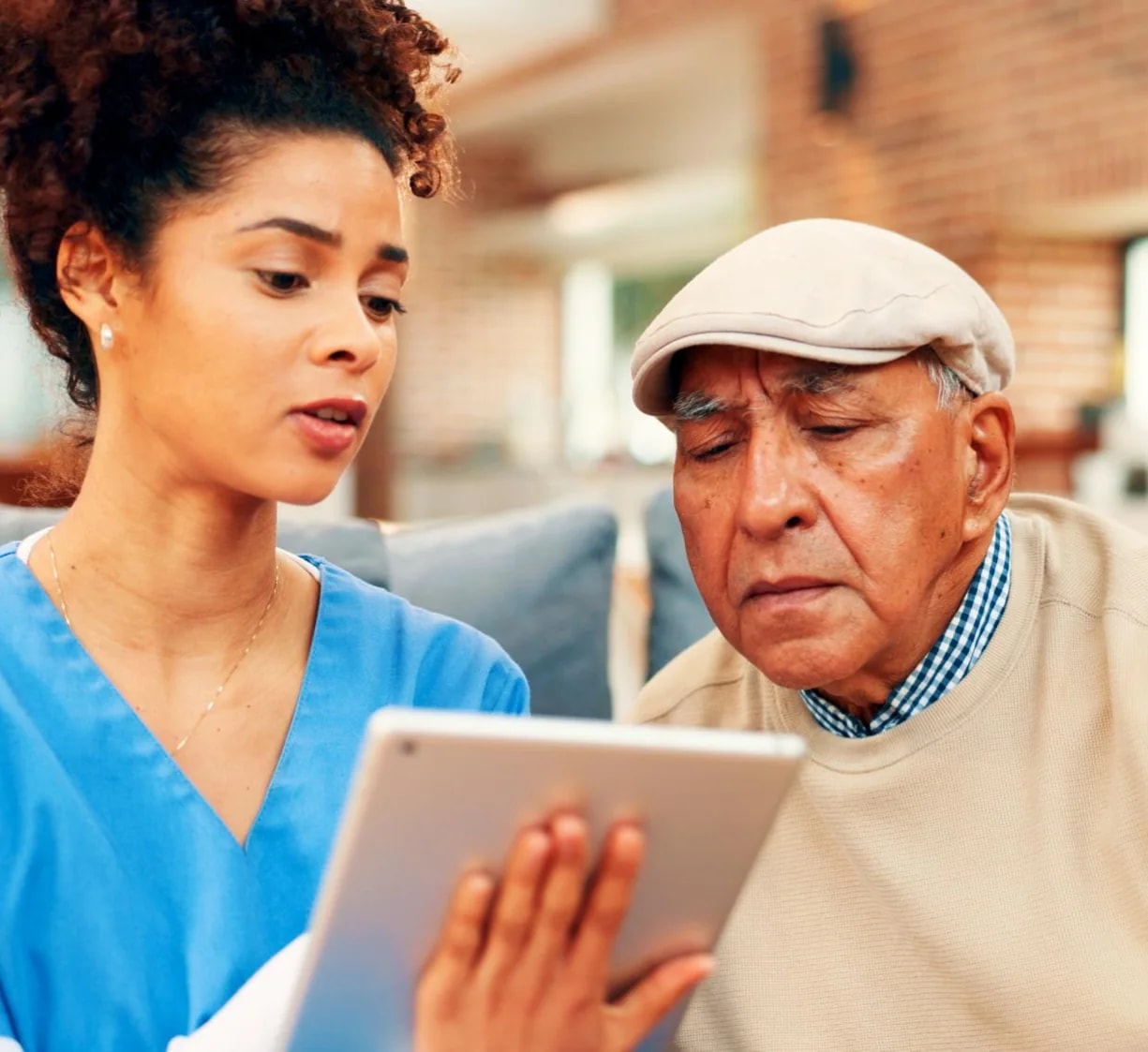 A nurse going through something on a tablet with an older man.
