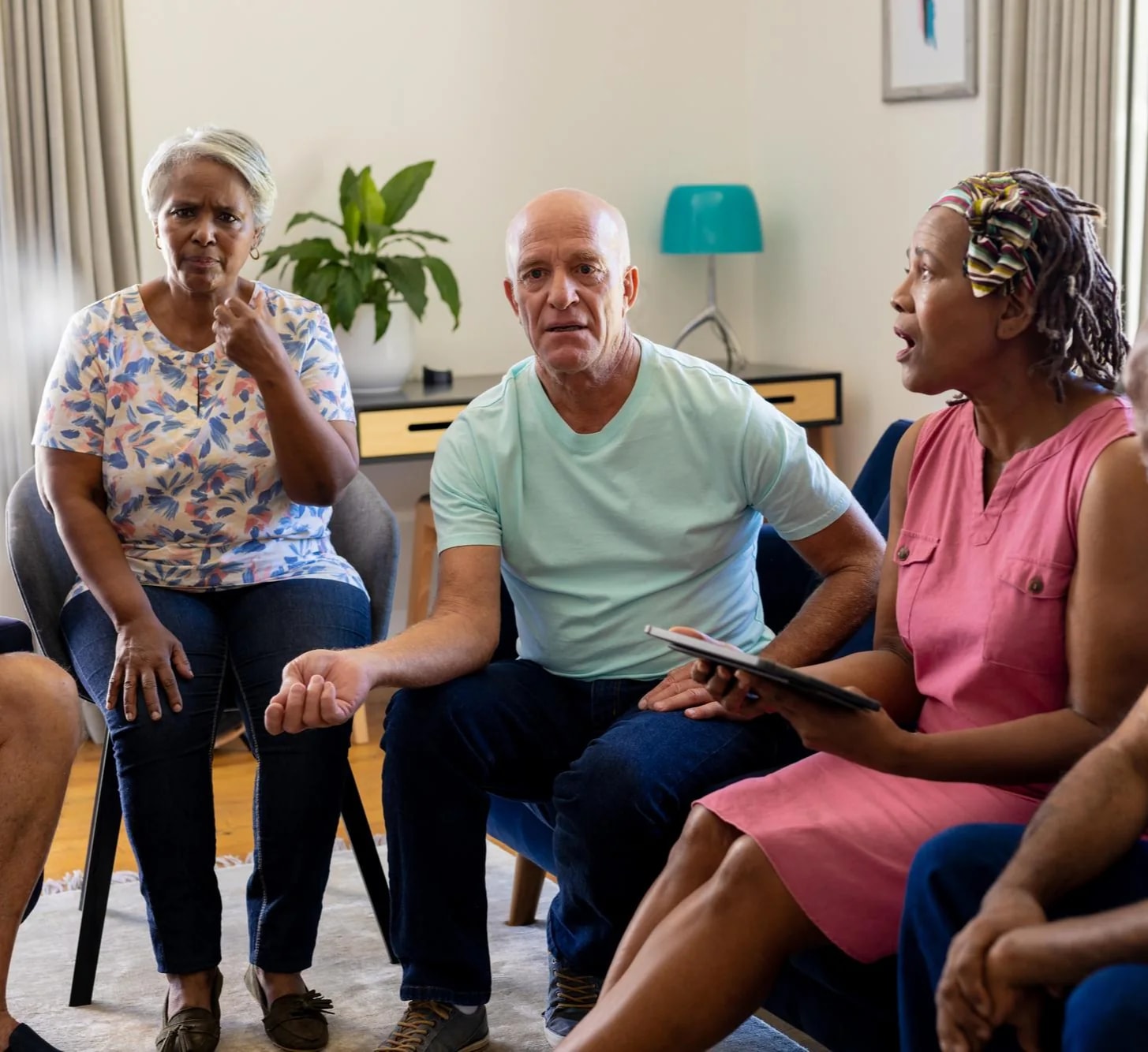 An older couple and two relatives talking together in a sitting room.