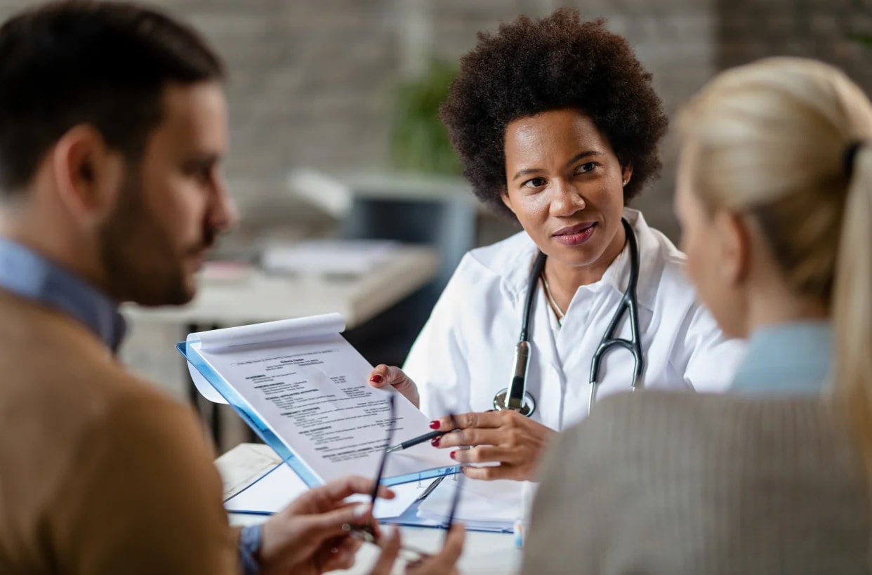 A family discussing a care plan with an older parent at the dining table.
