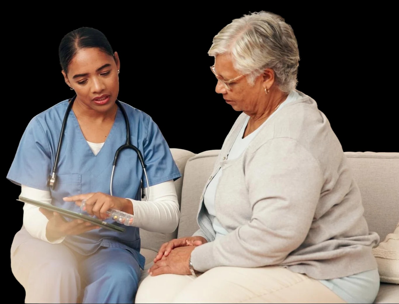 A nurse going through a care plan on a tablet with an older woman.