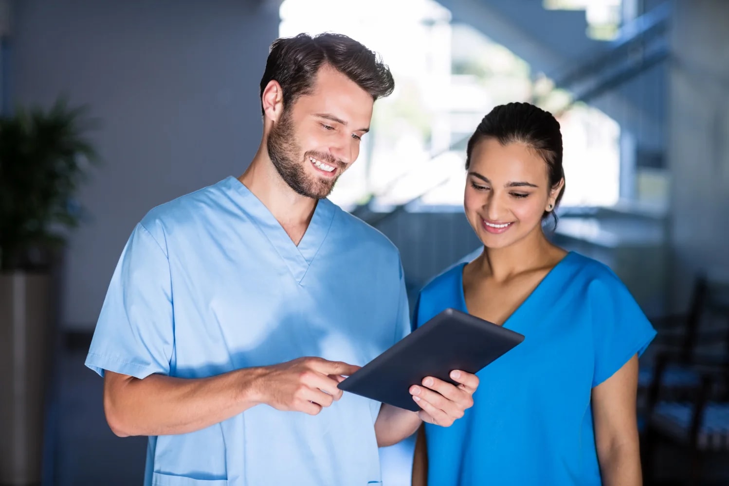 Two care staff going through the shift board on a tablet.
