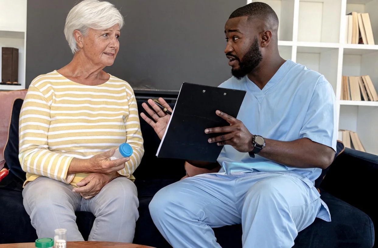 A familiar carer sharing a cup of tea with an older man.